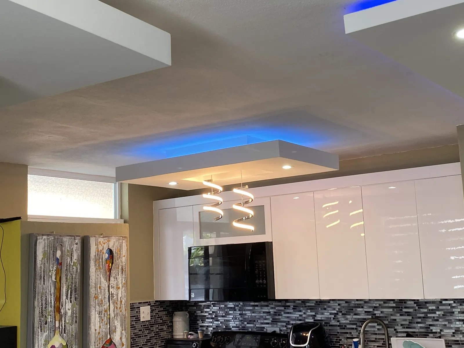 Ceiling with blue LED cove lighting over a family room